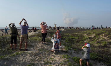 People watch as SpaceX's next-generation Starship spacecraft atop its powerful Super Heavy rocket lifts off from the company's Boca Chica launchpad on a brief uncrewed test flight near Brownsville