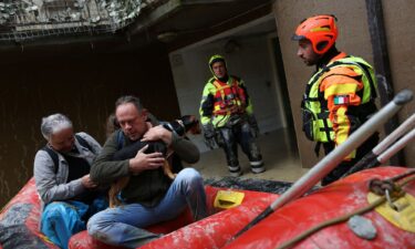 Rescue workers evacuate people and a dog from a flooded house in Faenza on Friday.