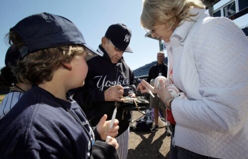New York Yankees Hall of Fame catcher Yogi Berra signs autographs for special guests of the Yankees before team's spring training baseball game against the Toronto Blue Jays at Steinbrenner Field in Tampa