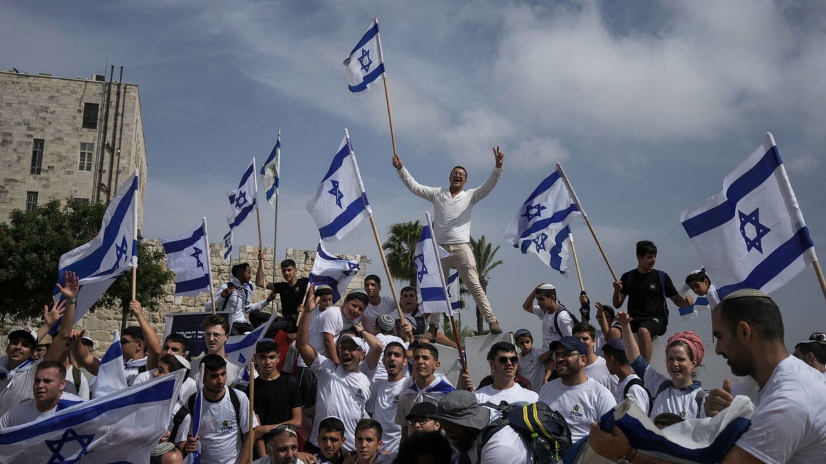 <i>Maya Alleruzzo/AP</i><br/>Israelis wave national flags during a march marking Jerusalem Day