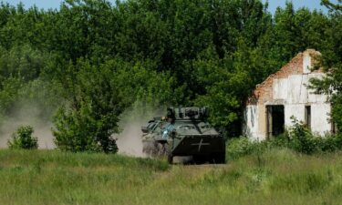 A Ukrainian BTR armored personnel carrier races across a field as part of a military drill.