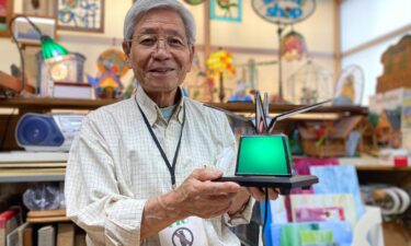 Okihiro Terao holds up a stained-glass crane that he made to symbolize peace. He said he sent one decorated in the colors of the Ukrainian flag to the Ukrainian embassy in Tokyo.