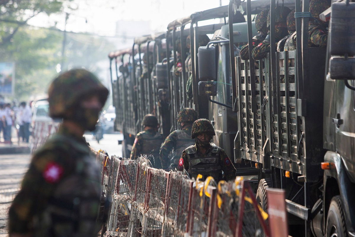 <i>Stringer/Reuters</i><br/>Soldiers stand next to military vehicles as people gather to protest against the military coup