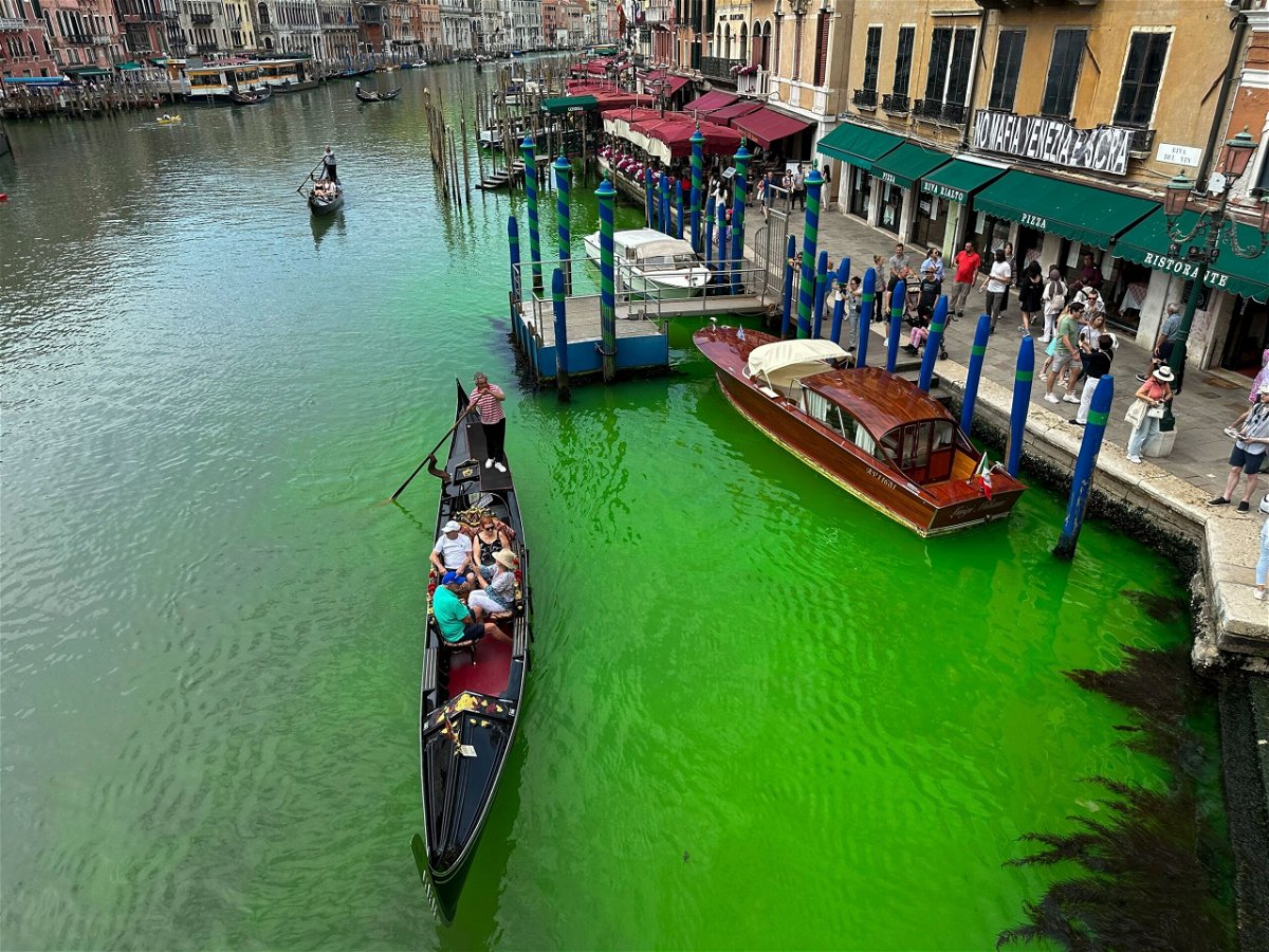<i>Luigii Costantini/AP</i><br/>A gondola crosses Venice's historical Grand Canal as a patch of phosphorescent green liquid spreads in it