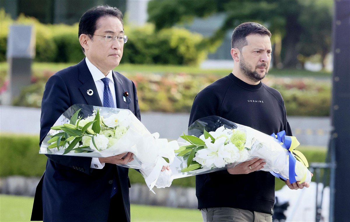<i>Kyodo News/Getty Images</i><br/>Japanese Prime Minister Fumio Kishida (left) and Ukrainian President Volodymyr Zelensky walk toward the cenotaph for atomic bomb victims at the Peace Memorial Park in Hiroshima on May 21.