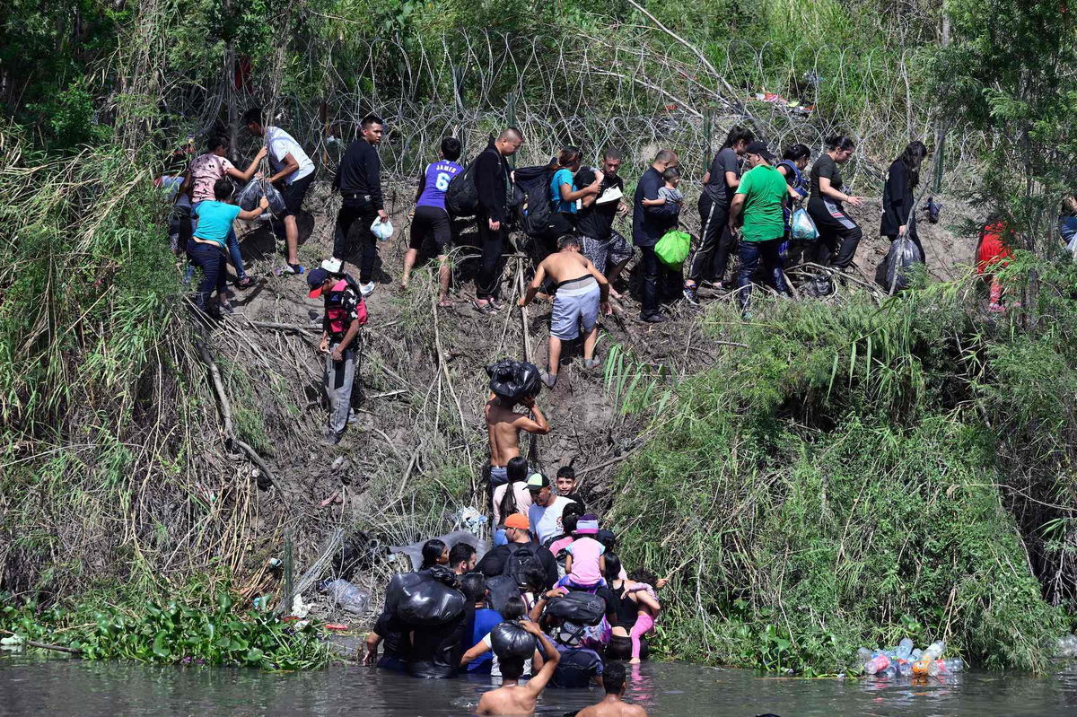 Migrant people try to get to the US through the Rio Grande, which is reinforced with a barbed-wire fence, as seen from Matamoros, state of Tamaulipas, Mexico on May 10, 2023. A surge of migrants is expected at the US-Mexico border cities as President Biden administration is officially ending its use of Title 42. On May 11, President Joe Biden's administration will lift Title 42, the strict protocol implemented by previous president Donald Trump to deny entry to migrants and expel asylum seekers based on the Covid pandemic emergency. (Photo by ALFREDO ESTRELLA / AFP) (Photo by ALFREDO ESTRELLA/AFP via Getty Images)