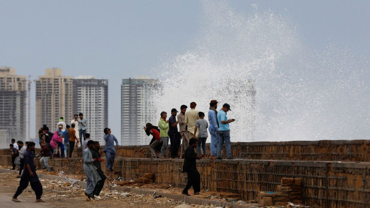 <i>Akhtar Soomro/Reuters</i><br/>People gather near the rising waves