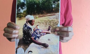 Rodgers Shibutse holds a picture of his missing mother Pamela.