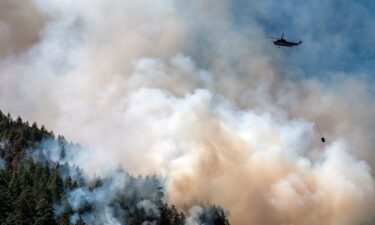 A helicopter waterbomber flies above the Cameron Bluffs wildfire near Port Alberni