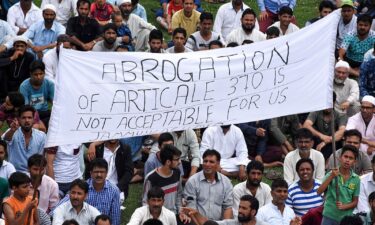 Kashmiri boys hold a banner during a protest against the revoke of controversial Article 370 by Indian government in Srinagar while curfew continues on the fifth day in Kashmir