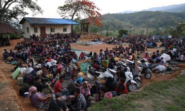 People wait at a temporary shelter in a military camp on May 7