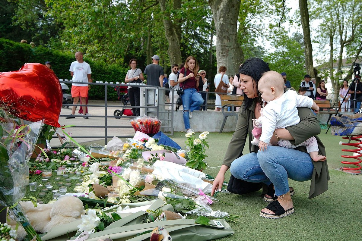 <i>Peter Byrne/AP</i><br/>People lay flowers near the scene at a lakeside park in Annecy