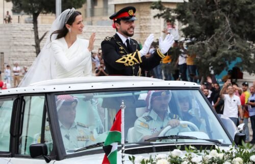 Jordan's Crown Prince Hussein (right) and Rajwa Alseif wave to crowds on their wedding day in Amman.