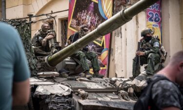 Members of Wagner group sit atop of a tank in a street in the city of Rostov-on-Don