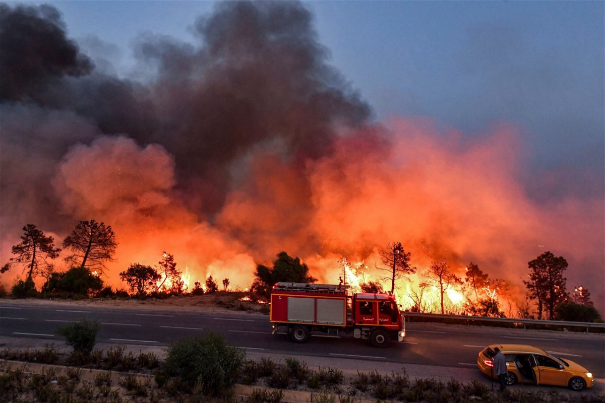 <i>Fethi Belaid/AFP/Getty Images</i><br/>A fire truck moves along a road as a forest fire rages near the town of Melloula in northwestern Tunisia on July 24.