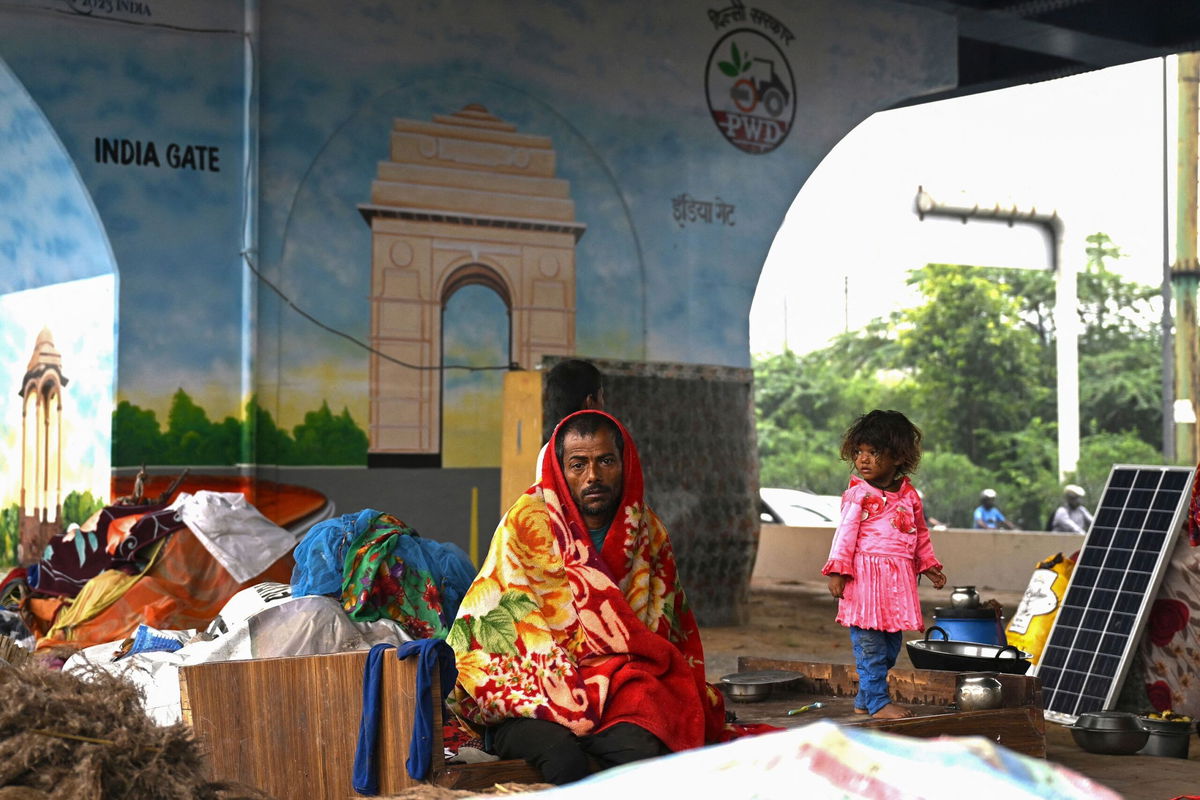 <i>Money Sharma/AFP/Getty Images</i><br/>People shelter under a flyover road after relocating from low lying areas near the Yamuna River after it overflowed due to monsoon rains in New Delhi on July 11.