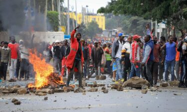 Protesters stand by a burning barricade on a street in the Mathare neighborhood of Nairobi