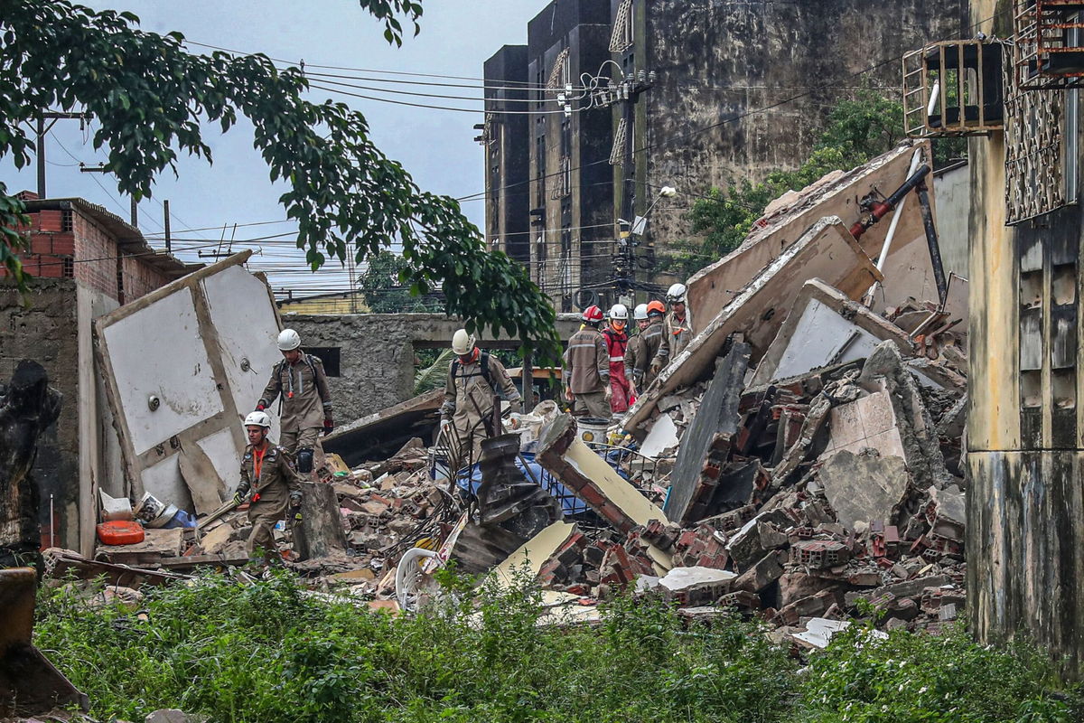 <i>Carlos Ezequiel Vannoni/EPA-EFE/Shutterstock</i><br/>Rescuers search for survivors under the rubble of the collapsed building.