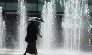 A pedestrian uses an umbrella to shade from the sun during a heat wave in Beijing on July 6