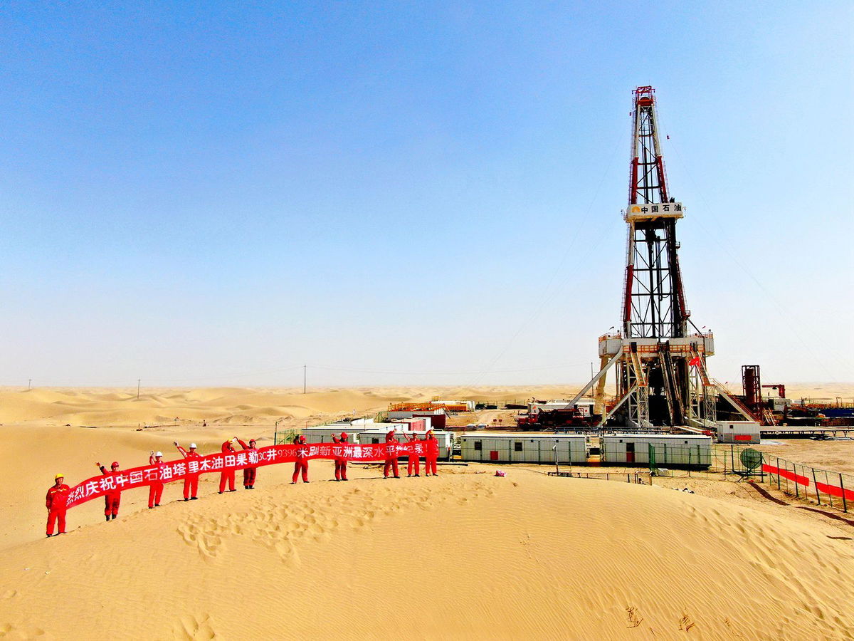 <i>Tan Hui/VCG/Getty Images/File</i><br/>Oil workers hold a banner at Tarim Oilfield at Taklimakan Desert in Shaya County on March 9