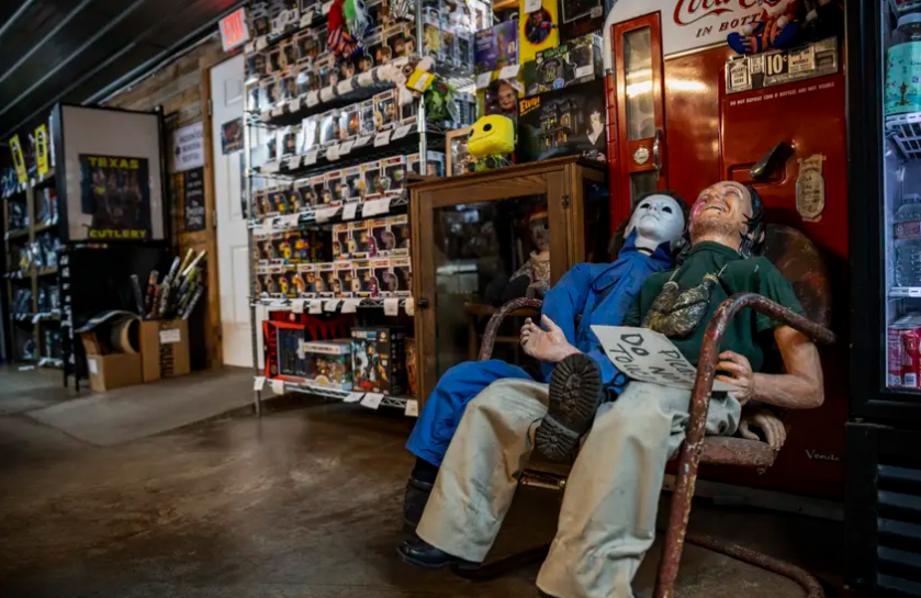 Two life-sized horror movie dummies sit in front of a movie prop vending machine at We Slaughter BBQ in Bastrop on Oct. 27. The roadside rest stop and tourist attraction, now restored, is one of several Central Texas locations where the 1974 film 