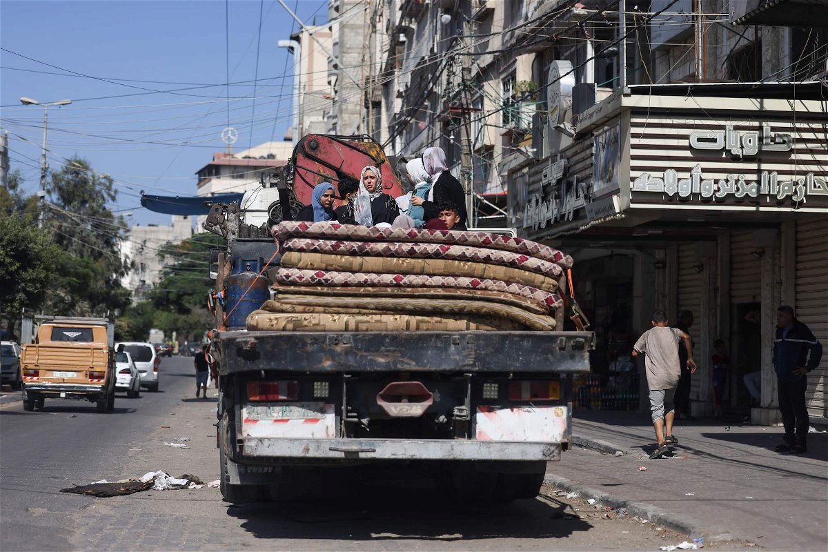 Palestinians with their belongings flee to safer areas in Gaza City after Israeli air strikes on October 13.