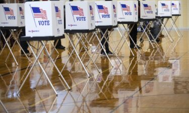 An election official wears a protective mask while waiting to assist voters at a polling location in Dearborn Heights