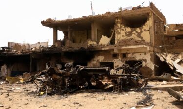 A damaged car and buildings are seen at the central market during clashes between the paramilitary Rapid Support Forces and the army in Khartoum North