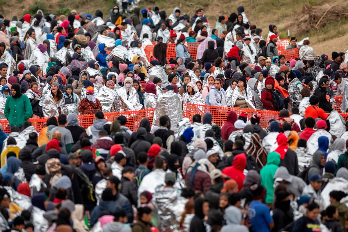 Immigrants wait to be processed at a U.S. Border Patrol transit center after they crossed the border from Mexico on December 20, in Eagle Pass, Texas.