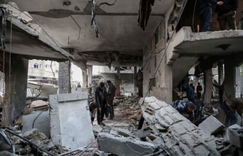 People inspect damage to their homes following Israeli air strikes on February 24