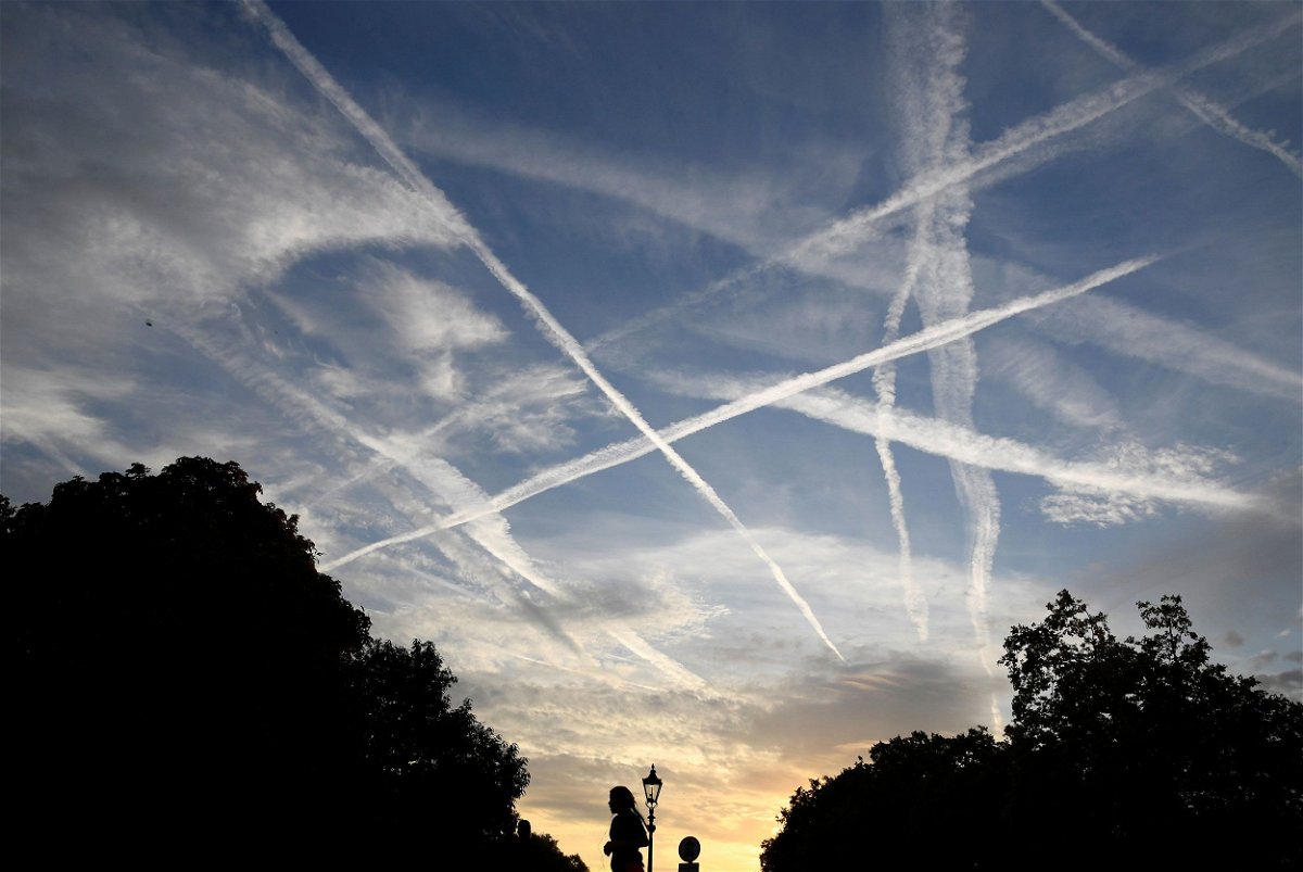 Aircraft contrails in the sky at dawn in London. Many people believe these contrails are actually dangerous or being used for conspicuous purposes.