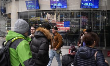 Pedestrians walk past the Nasdaq building Tuesday