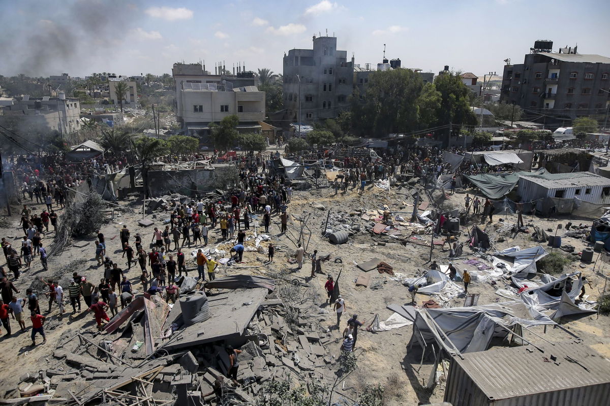 <i>Jehad Alshrafi/AP via CNN Newsource</i><br/>Palestinians inspect the damage at a site hit by an Israeli bombardment on Khan Younis on Saturday.