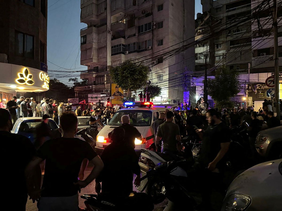 People gather near a site hit by what security sources said was a strike on the southern suburbs of Beirut, Lebanon, on July 30, 2024.