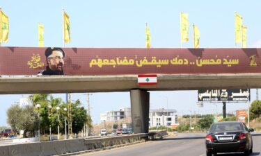 Hezbollah flags are erected along with a banner showing assassinated Hezbollah commander Fuad Shukr in southern Lebanon.