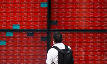 A man looks at an electronic quotation board displaying stock prices of the Nikkei 225 on the Tokyo Stock Exchange in Tokyo on August 6