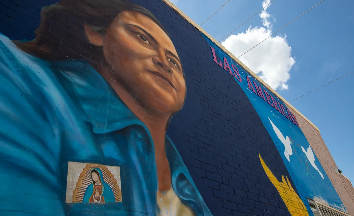 A woman carrying a small Virgin of Guadalupe image and a torch is part of a mural on the Central El Paso building that houses the Las Americas Immigrant Advocacy Center.