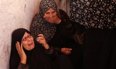 Palestinians inspect the damage at the site of the Israeli strike.