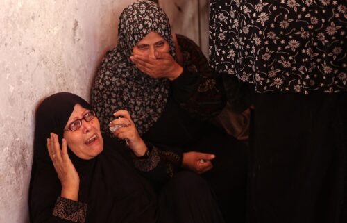 Palestinians inspect the damage at the site of the Israeli strike.