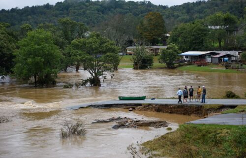 Residents talk after having canoed the flooded South Fork New River for 32 minutes and landing at a washed out road on September 27