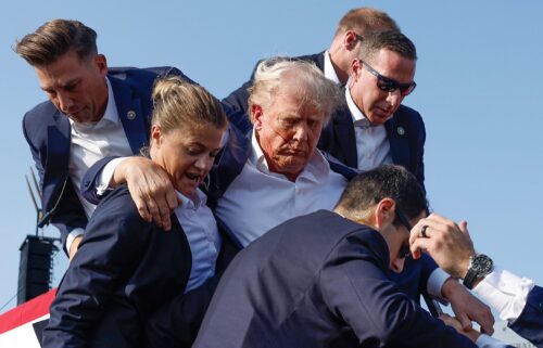 Republican presidential candidate former President Donald Trump is rushed offstage by US Secret Service agents after being grazed by a bullet during a rally on July 13